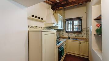 Una cocina compacta con refrigerador, estufa y lavamanos.