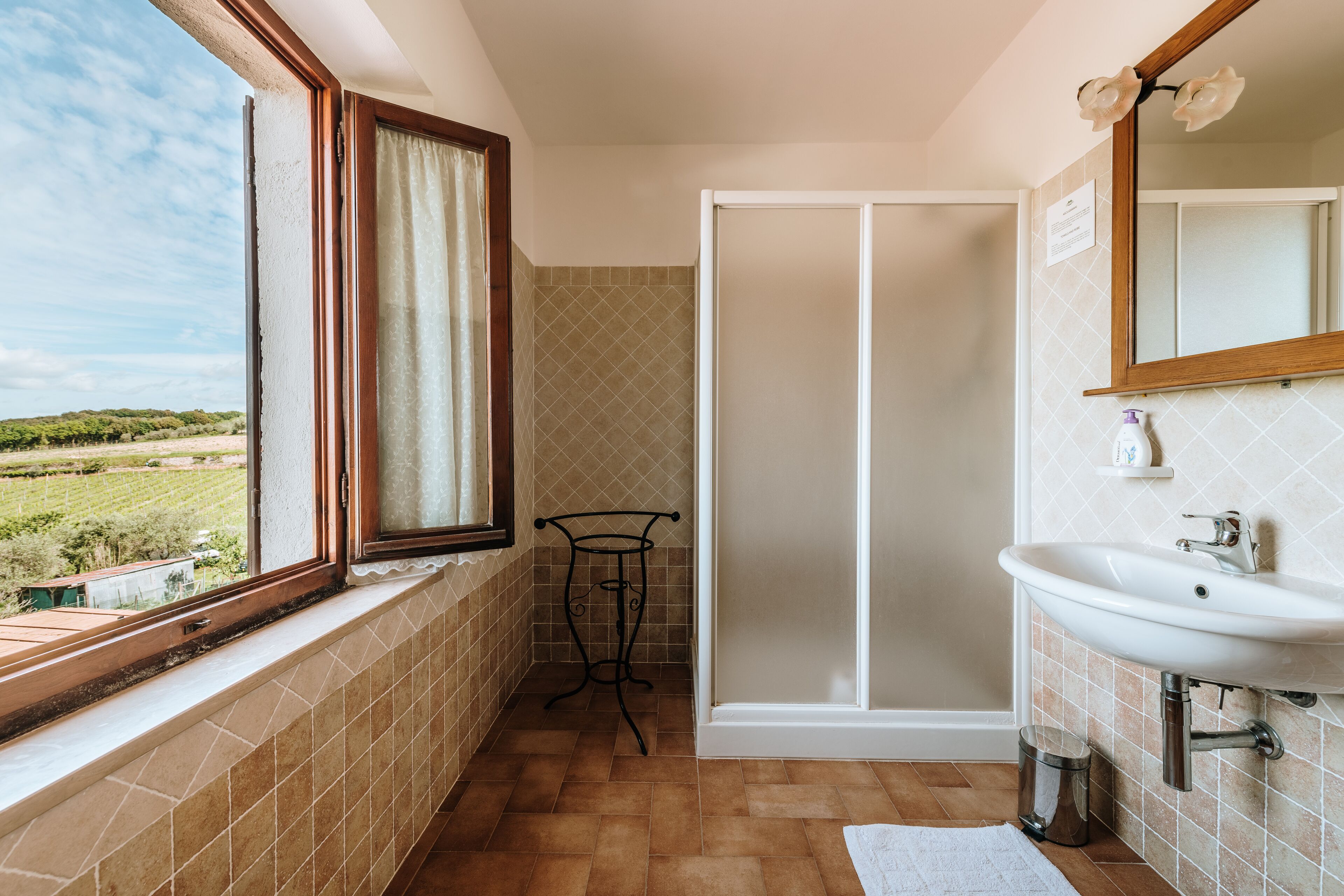 Une salle de bain avec une fenêtre, un lavabo et une douche.