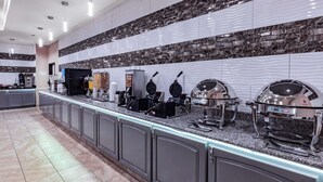 Una cocina moderna con una barra larga, diversos electrodomésticos y un salpicadero decorativo.