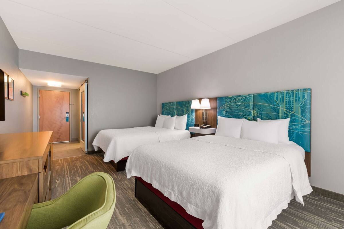 Escritorio, cortinas blackout y tabla de planchar con plancha