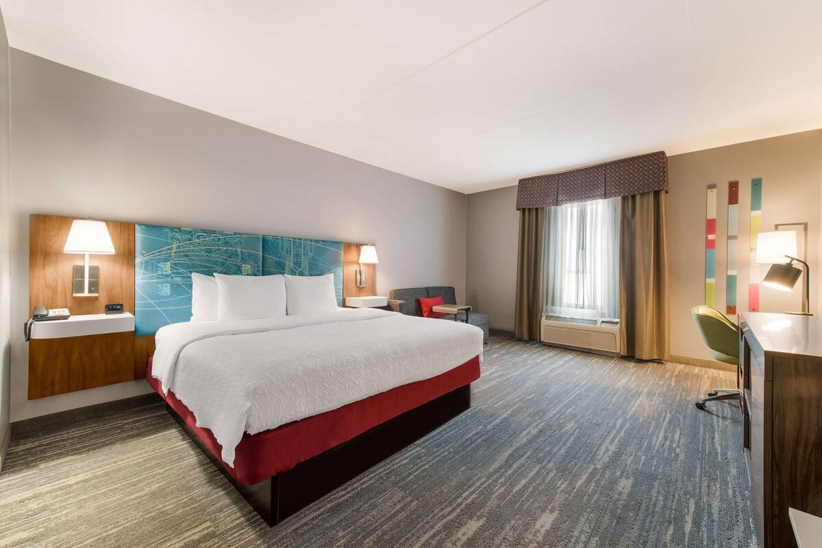 Escritorio, cortinas blackout y tabla de planchar con plancha