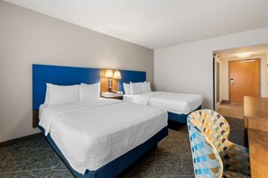 A hotel room with a large bed, a smaller bed, a desk, and a chair. - Hampton Inn & Suites Charlotte Airport (Charlotte)