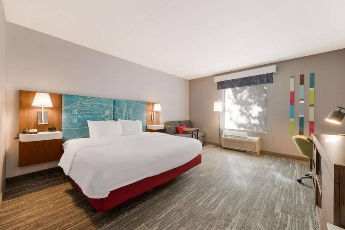 Escritorio, cortinas blackout y tabla de planchar con plancha