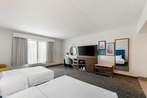 A hotel room with two beds, a TV, a desk with a chair, a mirror, and artwork on the wall. - Hampton Inn & Suites Charlotte Airport (Charlotte)