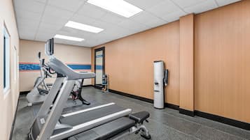 A gym with treadmills, a stationary bike, and a wall-mounted exercise machine.