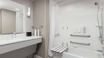 A modern bathroom with a white sink, mirror, and shower.