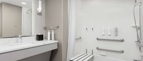 Une salle de bain moderne avec un lavabo blanc, un miroir et une douche.