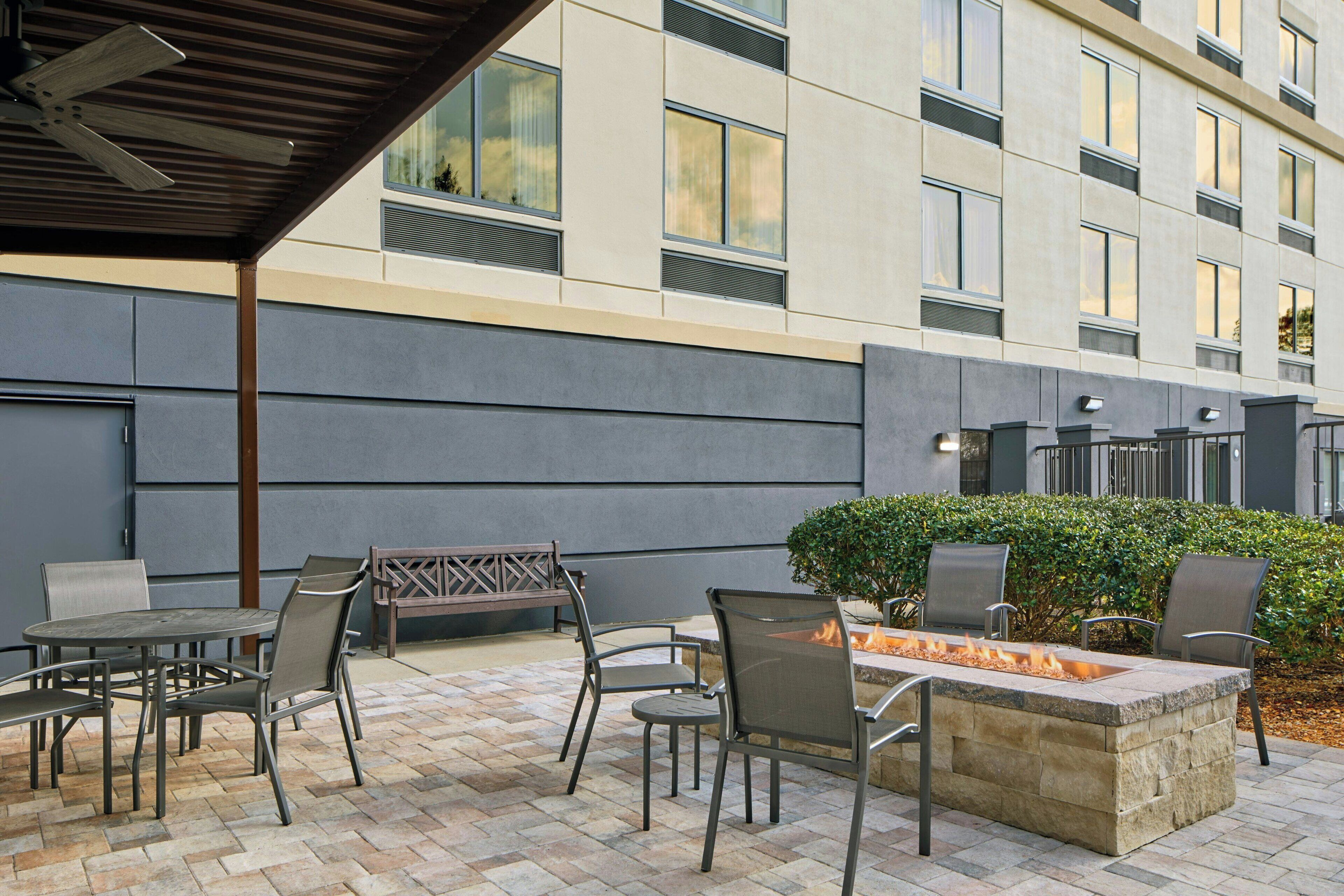 Patio esterno con borsa fuoco, posti a sedere e zona coperta con ventilatore a soffitto.