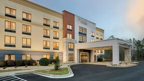 Een meerlaags hotel met een opvallend 'Fairfield by Marriott'-bord, een overdekte ingang en een aangelegde oprit.
