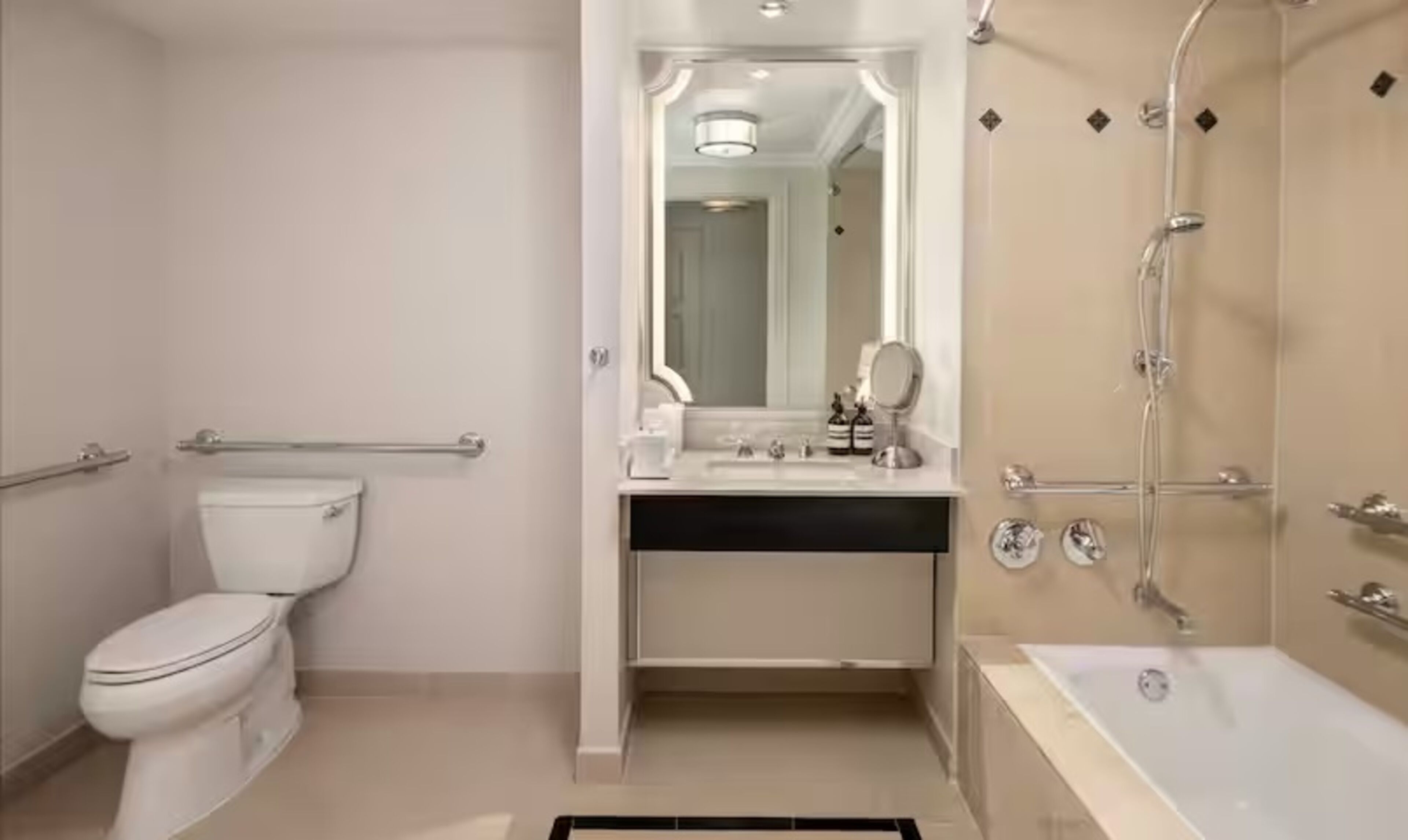 A modern bathroom with a toilet, sink, mirror, and shower.