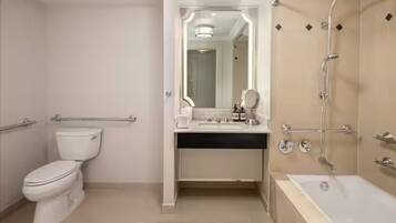 A modern bathroom with a toilet, sink, mirror, and shower.