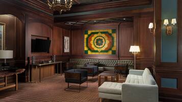 A hotel lobby with a bar, seating area, and a large decorative wall.