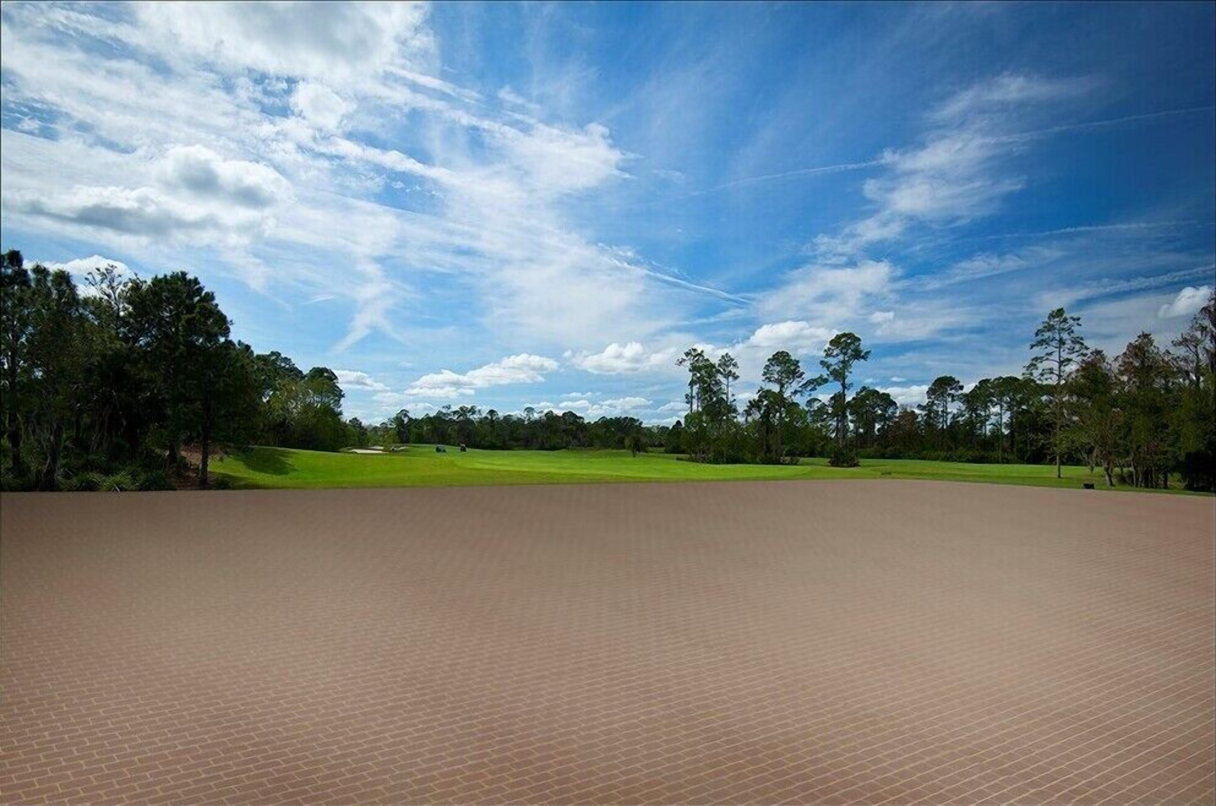 Une vaste zone ouverte, pavée de briques, d’où l’on peut admirer un terrain de golf et des arbres sous un ciel partiellement nuageux.