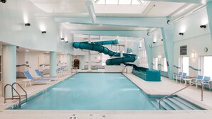 An indoor swimming pool with two slides, lounge chairs, and a clear ceiling. - Hampton Inn & Suites by Hilton Halifax - Dartmouth (Dartmouth)