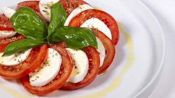 A plate of Caprese salad with tomatoes, mozzarella, and basil.