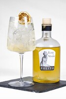 Una botella de Elisir di Venere Polito con corcho, y un vaso con hielo y una rodaja de naranja deshidratada.