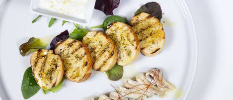 Une assiette blanche avec du pain grillé, un plat de poisson et un accompagnement de yaourt.