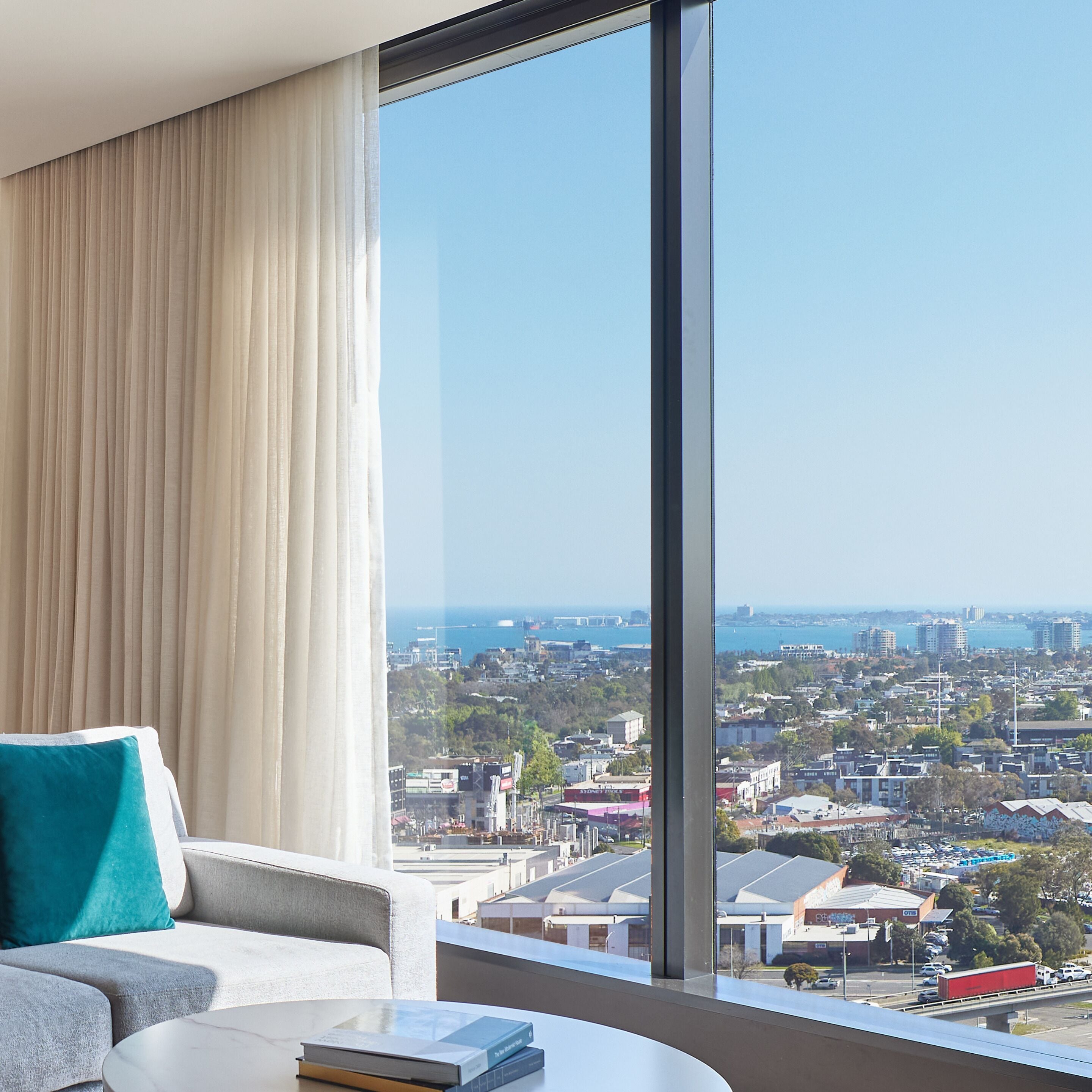 Ein modernes Hotelzimmer mit einem großen Fenster und Blick auf die Stadt.