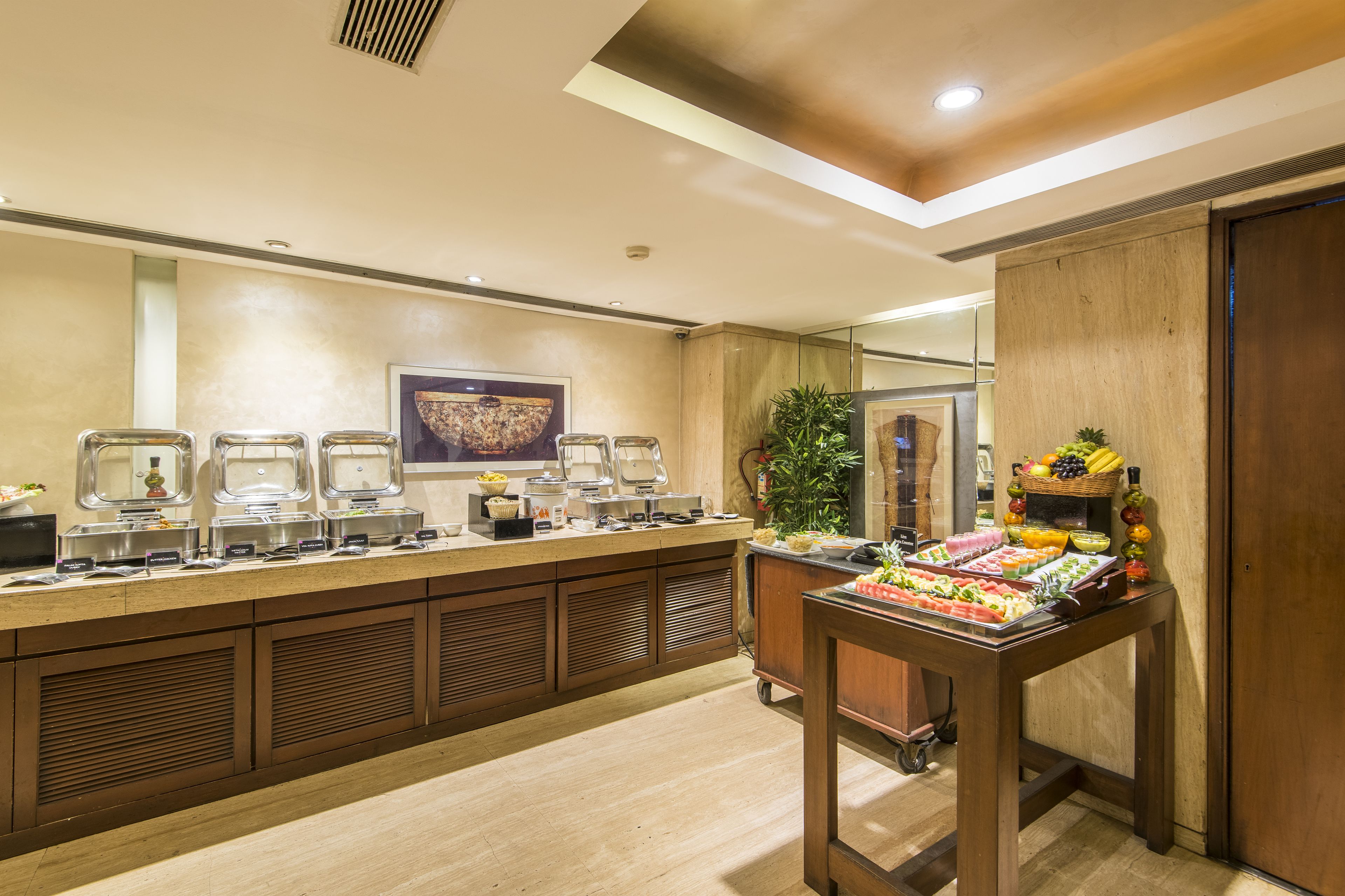 A buffet setup with multiple serving stations and a fruit display.
