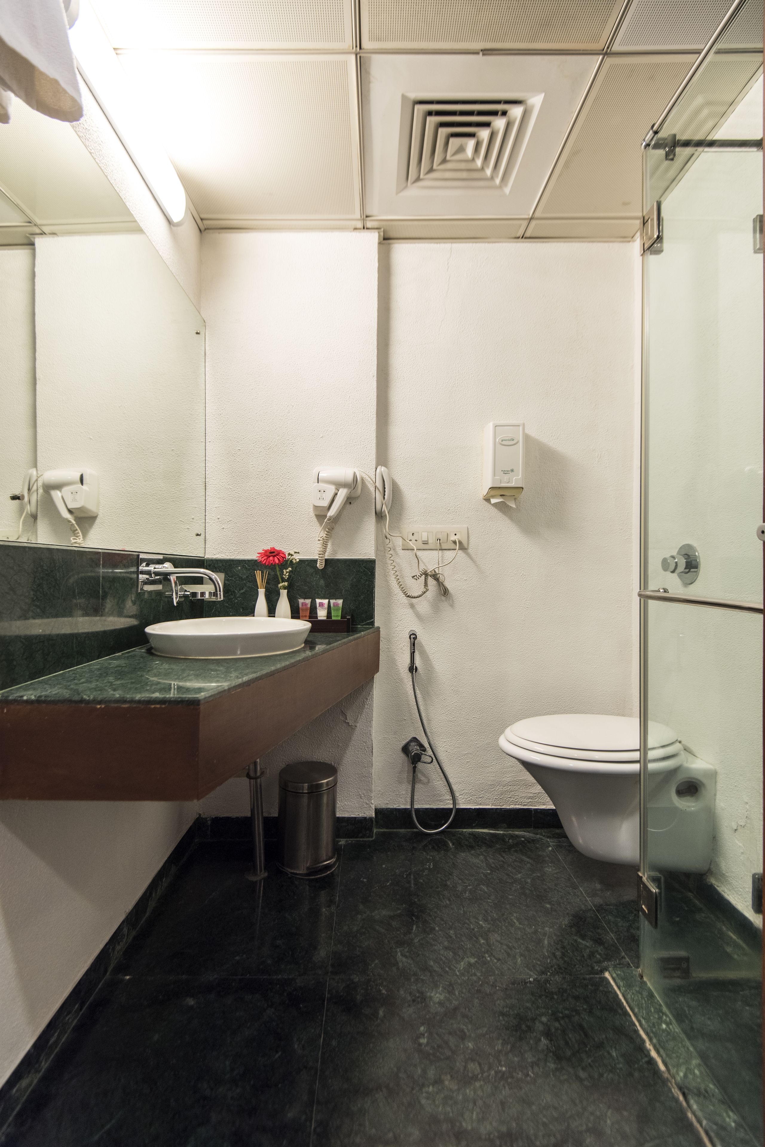 Een badkamer met een wastafel, spiegel, toilet en douche.