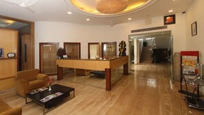 A spacious lobby with a reception desk, seating area, and a chandelier. - Phoenix Hotel (Pune)