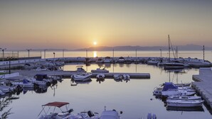 Um porto com barcos atracados em águas calmas ao pôr do sol.
