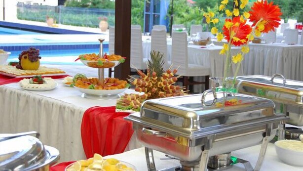 Ein reichhaltiges Buffet mit verschiedenen Speisen und einer dekorativen Blumenanordnung.