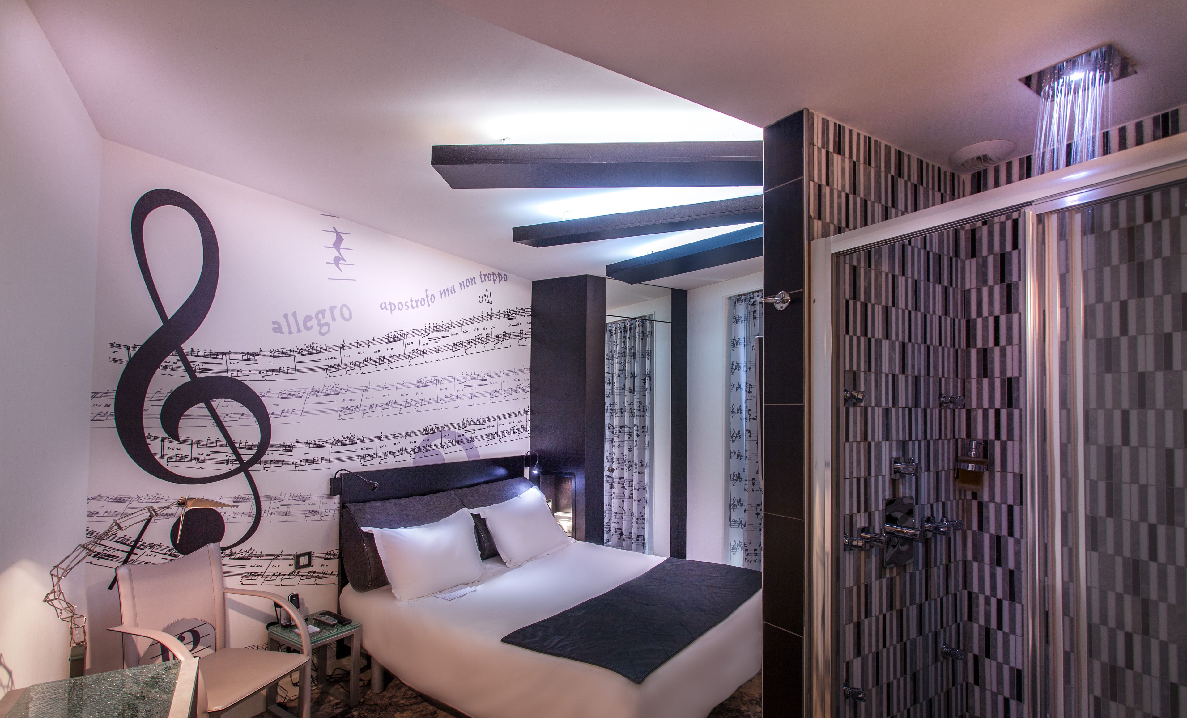 Ein modernes Schlafzimmer mit Bett, Schreibtisch und Duschbereich.