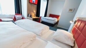A hotel room with two beds, a desk, a chair, and a TV on the wall. - Prinsen Hotel (Aalborg)