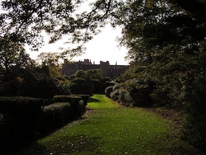 A well-maintained garden path leading to a historic building. - The Coachman's Quarters at Muncaster Castle (Ravenglass)
