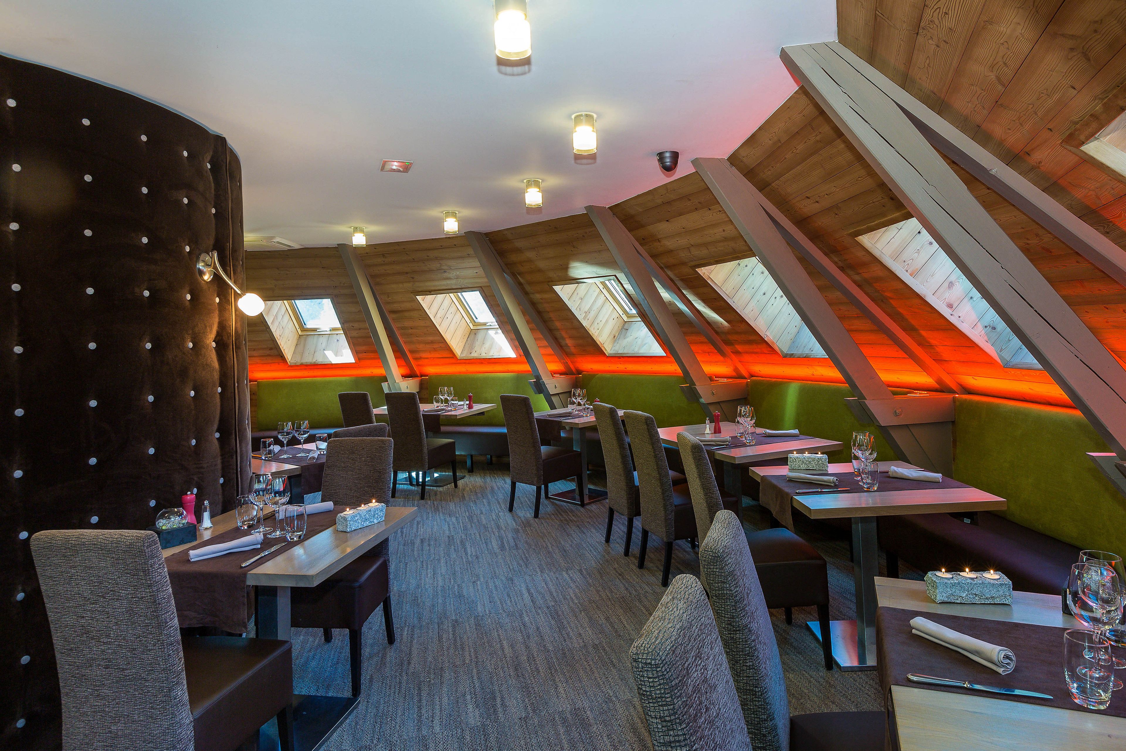 A restaurant with high ceilings, skylights, and a cozy seating arrangement.
