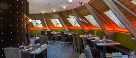 A restaurant with high ceilings, skylights, and a cozy seating arrangement.