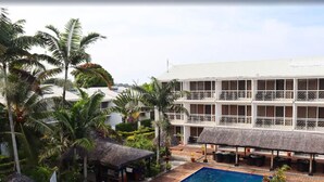 A multi-story hotel with a pool area, surrounded by palm trees and thatched-roof structures. - The Melanesian Port Vila Hotel (Port Vila)