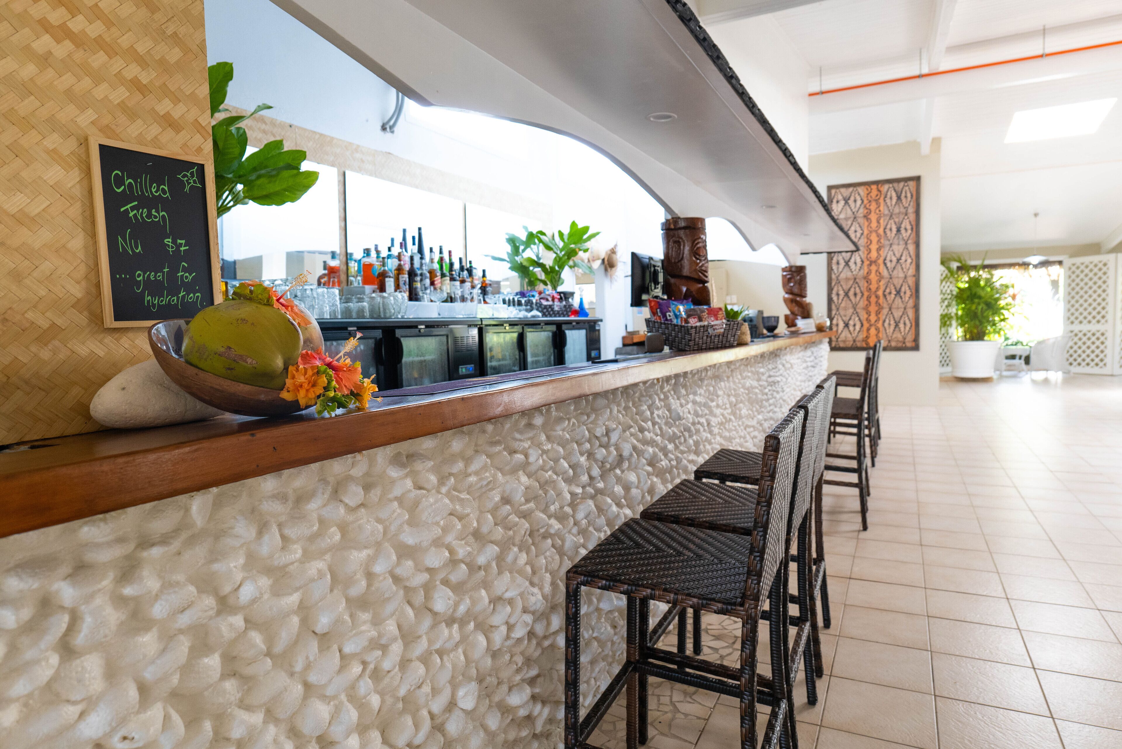 A bar area with a stone wall, a chalkboard menu, and a variety of bottles.