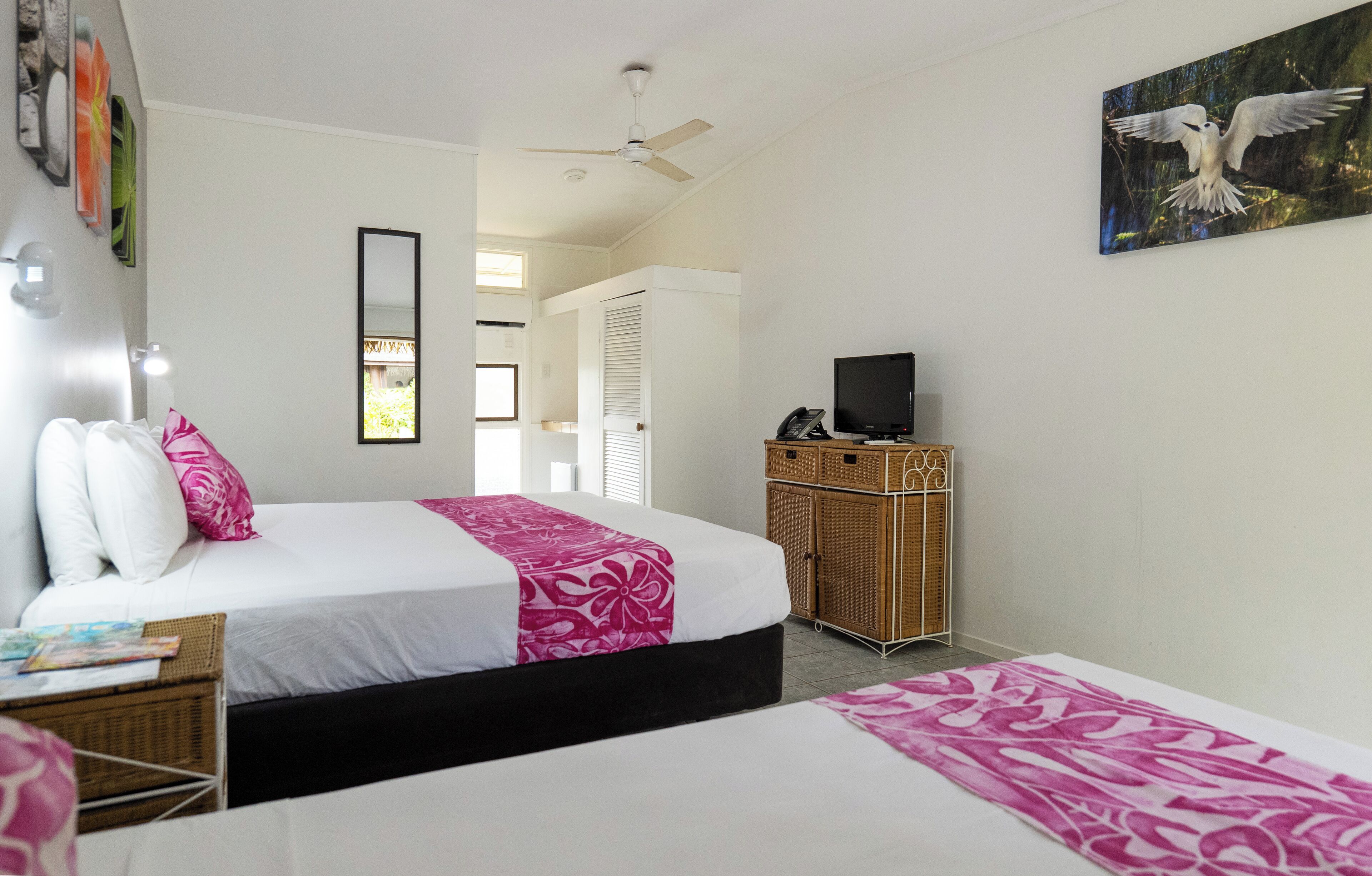 A bedroom with a bed, a television, and a wardrobe.