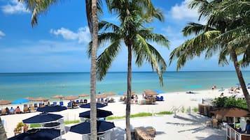 On the beach, white sand, sun loungers, beach umbrellas