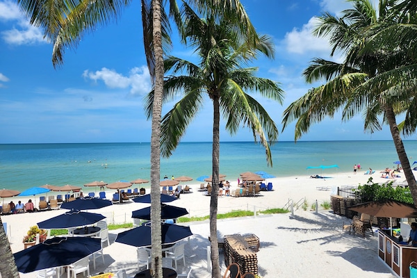 On the beach, white sand, sun-loungers, beach umbrellas