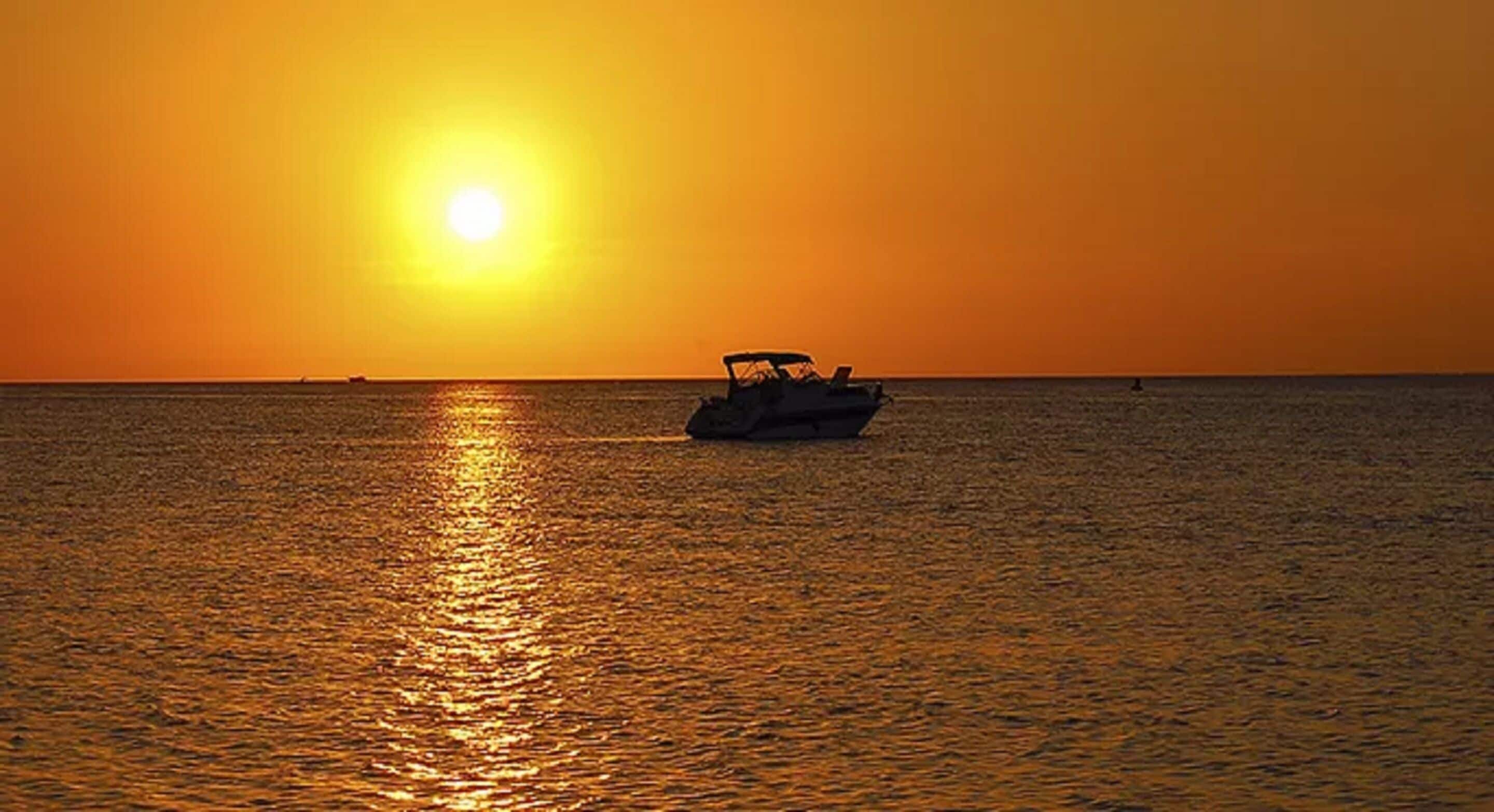 A boat on calm water during sunset.