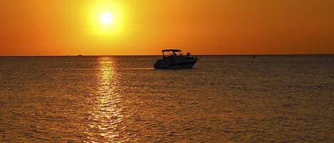 A boat on calm water during sunset.