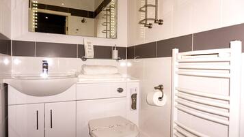 A modern bathroom with a sink, toilet, and towel rack.