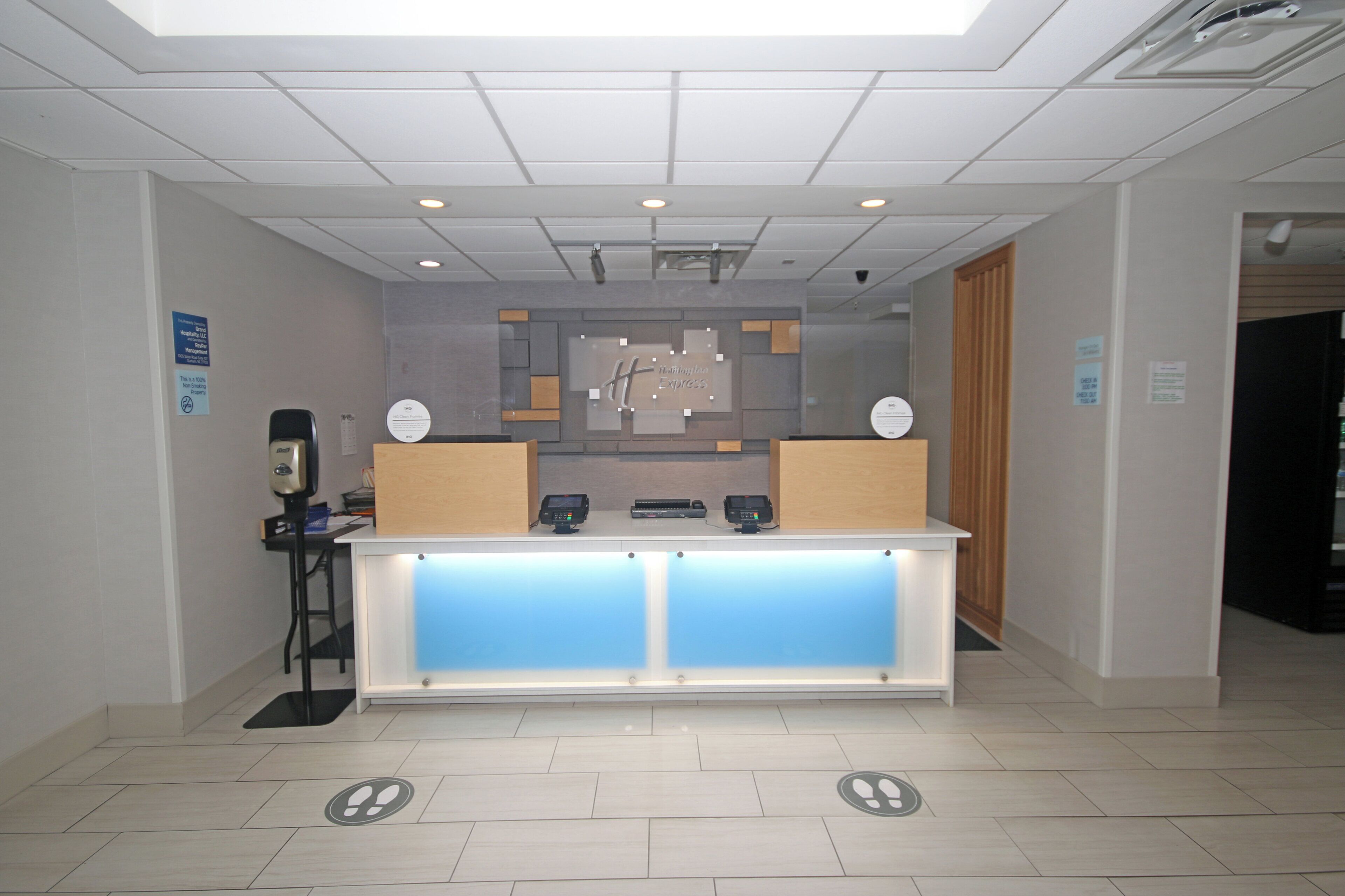A reception desk with a modern design, including a glass partition and two computer monitors.