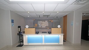 A reception desk with a modern design, including a glass partition and two computer monitors. - Holiday Inn Express Troutville by IHG (Troutville)