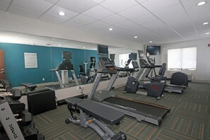 A gym with treadmills, elliptical machines, and weight equipment.