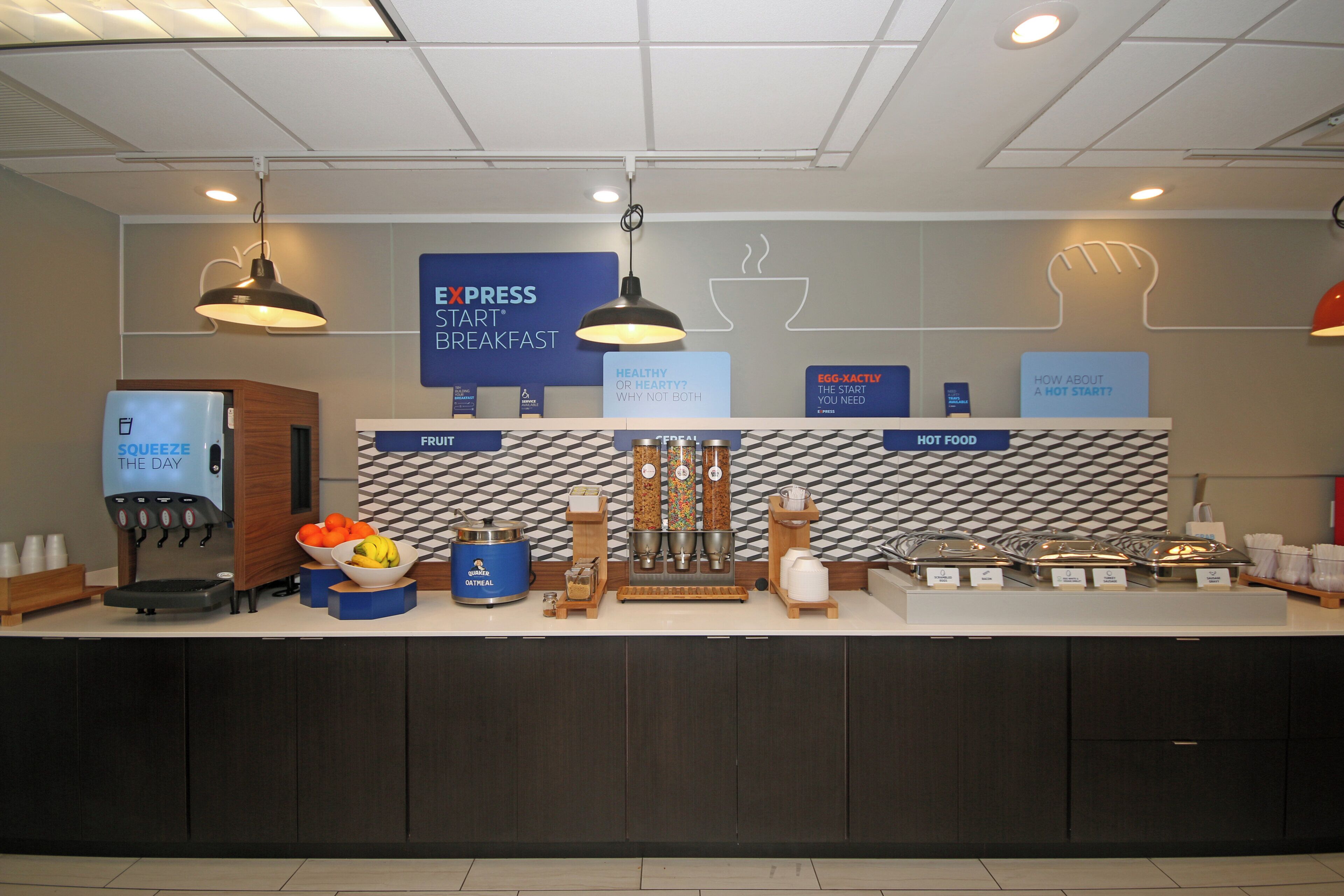 A breakfast bar with a coffee machine, fruit bowl, and various food containers.