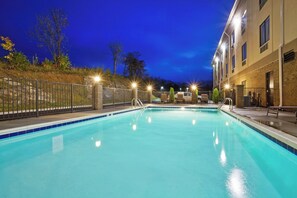 A swimming pool with a metal fence, a brick building, and a clear sky. - Holiday Inn Express Troutville by IHG (Troutville)