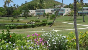 A resort with a pool, palm trees, and a building with a blue and white facade. - Crystal Cove Villas (St. Thomas)
