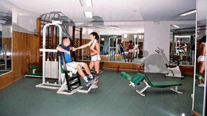 A gym with exercise equipment, mirrors, and a green floor. - Fresh Corralejo Garden (La Oliva)