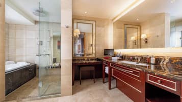 A modern bathroom with a glass-enclosed shower, a large vanity with a marble countertop, and a large mirror.