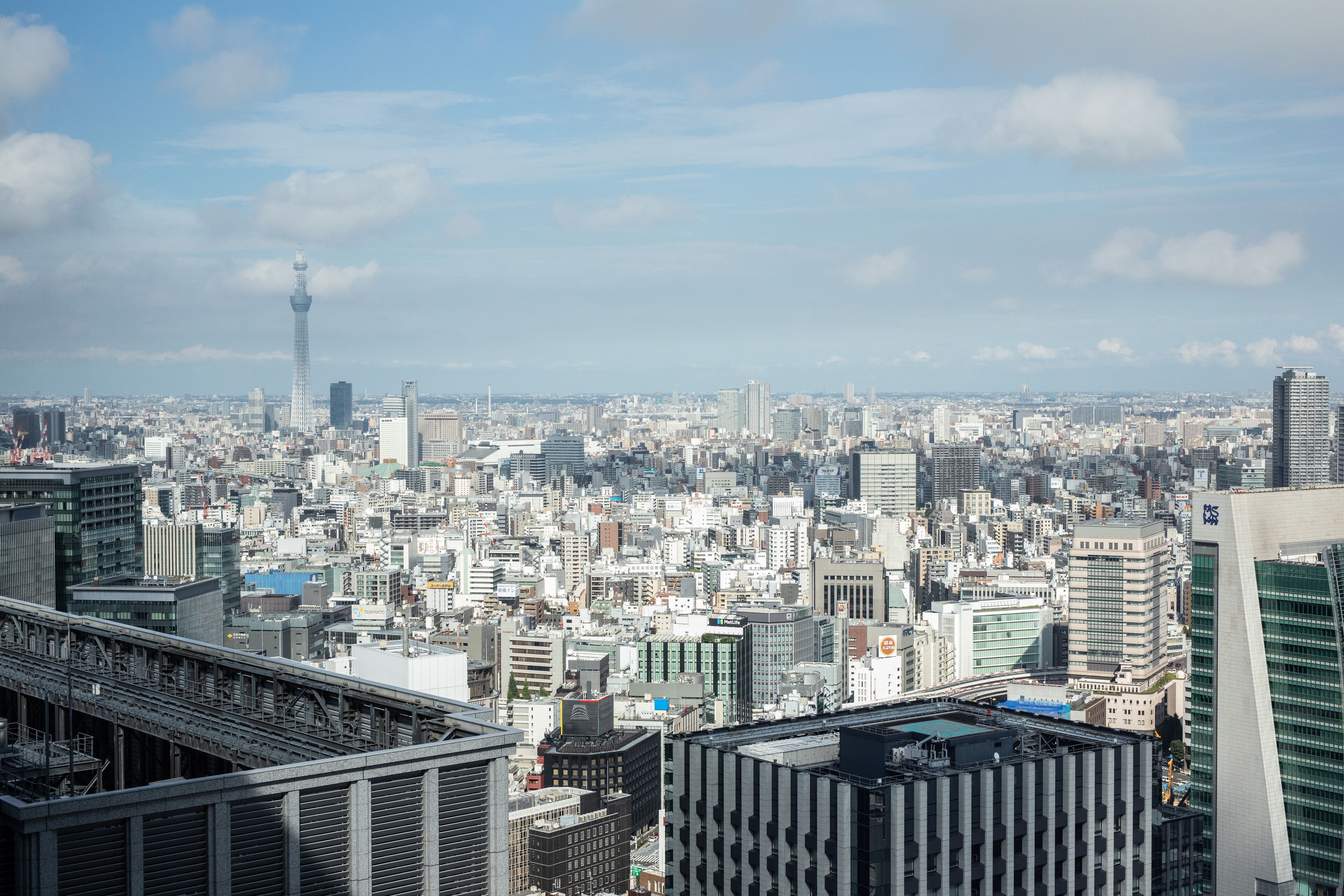 Un paisaje urbano con numerosos rascacielos, una torre destacada y una distribución urbana densa.