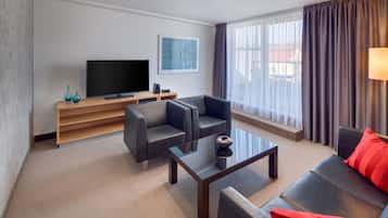 A modern living room with a flat-screen TV, two sofas, a coffee table, and a TV stand.